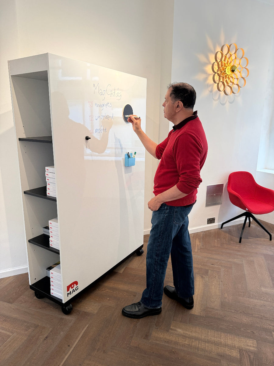 Person cleaning a white table with a red chair and light fixture in the background